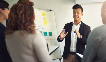 A man speaking to a group of people at work