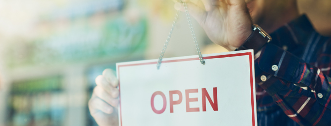 Business owner putting up "open" sign