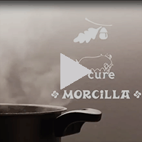A screenshot from a video. A pot steams while the logos for Enterprise Bank, Cure and Morcilla are visible. 