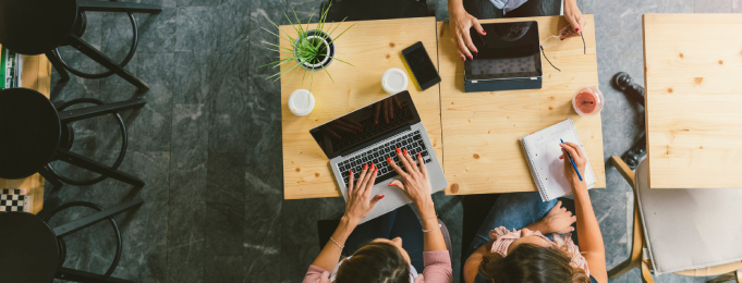 Top down view of people working at a wood table